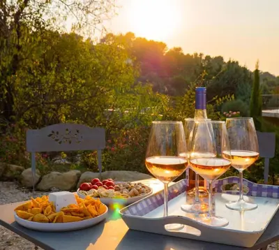 a table with two glasses of wine and a tray of food at La Collina De Rve in Apt