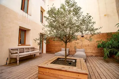 a courtyard with a tree and a bench at Le Baudelaire - magnifique appartement au cœur du centre historique in Aix-en-Provence