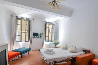 a bedroom with a bed and a couch and windows at Élégant Appartement Standing à 3min du Cours Mirabeau in Aix-en-Provence