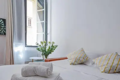 a bedroom with a white bed with a window at Élégant Appartement Standing à 3min du Cours Mirabeau in Aix-en-Provence
