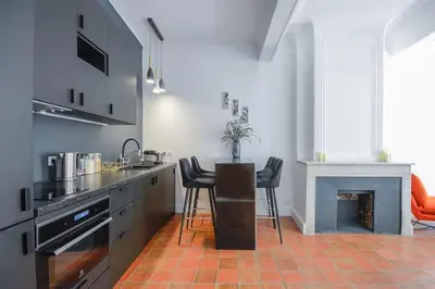 a kitchen with a table and chairs and a fireplace at Élégant Appartement Standing à 3min du Cours Mirabeau in Aix-en-Provence