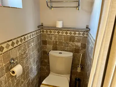 a bathroom with a toilet and a tiled wall at Studio at Mas Naste in Eygalières