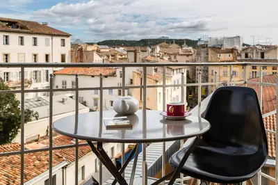 a table and chair on a balcony with a view of a city at Appartement vue superbe 70m2 2Balcons 2Chambres VRAI CLIMATISATION in Aix-en-Provence
