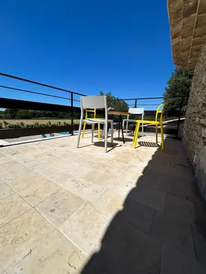 a table and chairs on a patio with the ocean at Charmante maison Provençale avec grand jardin in LʼIsle-sur-la-Sorgue