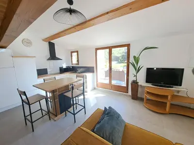 a kitchen and living room with a table and a couch at Gîte Le Dodo in Lançon-Provence