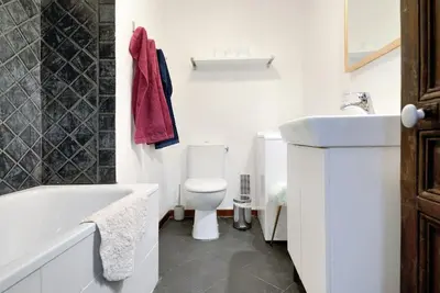 a white bathroom with a toilet and a sink at Appartement Vieille ville 55 m2 avec Terrasse 16m2 et 2chambres Vraie Climatisation in Aix-en-Provence