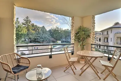 a balcony with a table and chairs and a window at Appartement moderne - Terrasse - Piscine - Parking in Ventabren