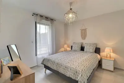 a bedroom with a bed and a chandelier at Appartement moderne - Terrasse - Piscine - Parking in Ventabren