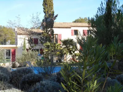 a house with a swimming pool in a garden at Villa Boulou in Rognes