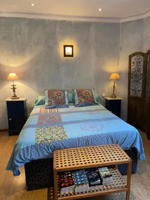 a bedroom with a bed with a blue blanket and two lamps at Charmant duplex bucolique, piscine, en Provence in Le Beaucet