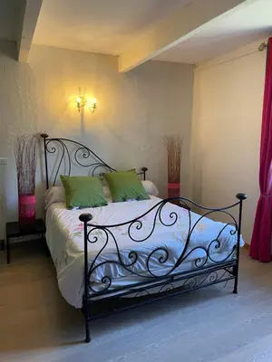 a bedroom with a black bed with green pillows at Charmant duplex bucolique, piscine, en Provence in Le Beaucet