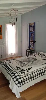 a bedroom with a bed with a black and white blanket at La restanque in La Tour-dʼAigues