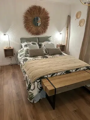 a bedroom with a large bed and a wooden table at Cocon cosy appart romantique, jacuzzi piscine in Puget