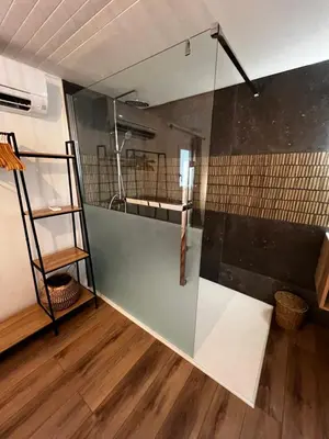 a bathroom with a glass shower with a sink at Cocon cosy appart romantique, jacuzzi piscine in Puget