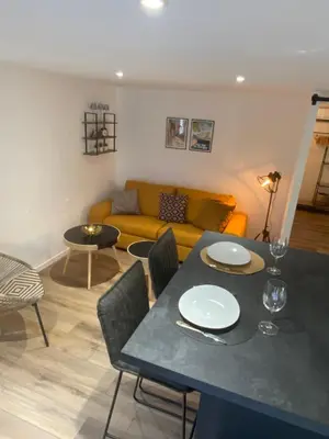 a living room with a table and a couch at Cocon cosy appart romantique, jacuzzi piscine in Puget