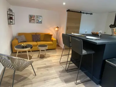 a living room with a yellow couch and a table at Cocon cosy appart romantique, jacuzzi piscine in Puget