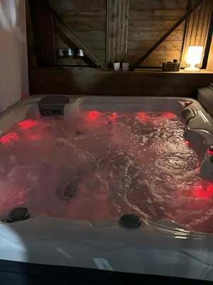 a hot tub filled with red water in a room at Cocon cosy appart romantique, jacuzzi piscine in Puget