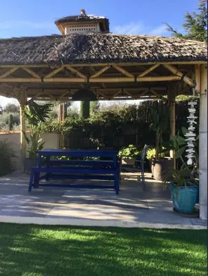 a blue bench under a gazebo in a yard at Villa aloha in Saint-Rémy-de-Provence