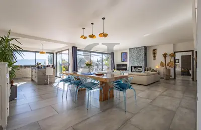 a kitchen and living room with a wooden table and chairs at Villa aloha in Saint-Rémy-de-Provence