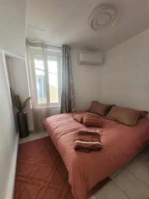 a large bed in a bedroom with a window at Appartement Au cœur de l'Isle in LʼIsle-sur-la-Sorgue