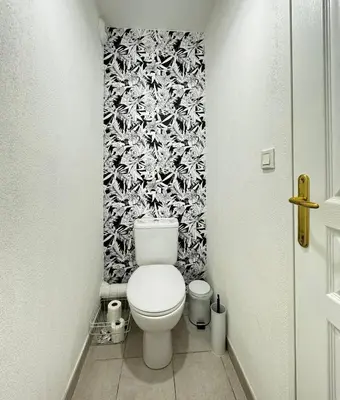 a bathroom with a toilet with a black and white wallpaper at Jungle Cosy - Gare - Bus - Parking gratuit - WIFI in Avignon