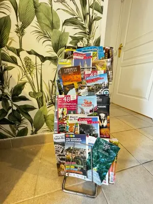 a pile of books on a rack in a room at Jungle Cosy - Gare - Bus - Parking gratuit - WIFI in Avignon