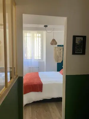 a bedroom with a bed with a red blanket at Le Petit Vendôme avec terrasse in Aix-en-Provence