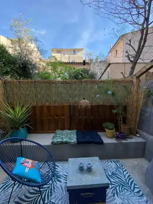 a patio with a chair and a table and a fence at Le Petit Vendôme avec terrasse in Aix-en-Provence