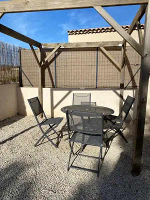a glass table and two chairs on a patio at Studio à la campagne in La Tour-dʼAigues