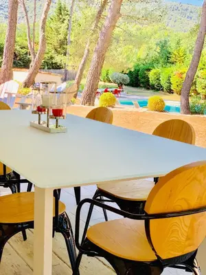 a white table and chairs with a view of a pool at Zen et Chic, juste à coté de la Bastide de Marie in Ménerbes