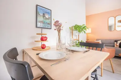 a dining room table with two white plates on it at Ô Cocon Provençal in LʼIsle-sur-la-Sorgue
