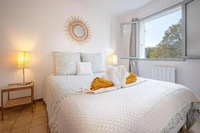 a white bed in a room with a window at Ô Cocon Provençal in LʼIsle-sur-la-Sorgue
