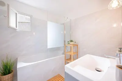 a bathroom with a white tub and a sink at Ô Cocon Provençal in LʼIsle-sur-la-Sorgue