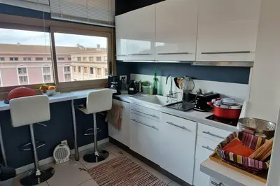 a kitchen with white cabinets and a large window at Le Ciel Bleu Clim Wifi Garage in Aix-en-Provence
