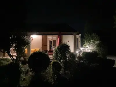 a house with an american flag at night at Villa 10 mins a pieds du centre de L Isle sur la Sorgue in LʼIsle-sur-la-Sorgue