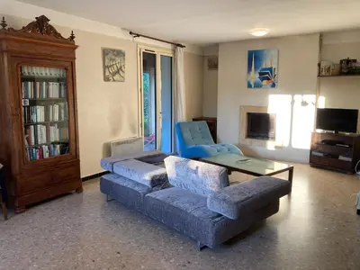 a living room with a couch and a table at Villa 10 mins a pieds du centre de L Isle sur la Sorgue in LʼIsle-sur-la-Sorgue