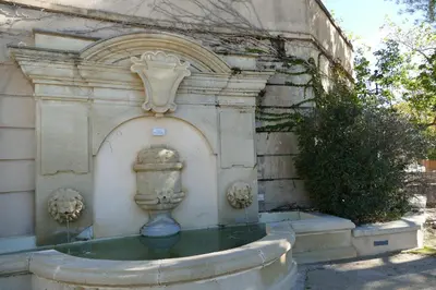 a fountain in the side of a building at Appartement clim & piscine sur Golf in Pont-Royal en Provence