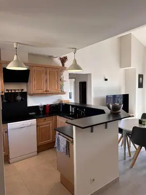 a kitchen with wooden cabinets and a black counter top at Appartement clim & piscine sur Golf in Pont-Royal en Provence