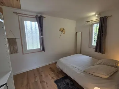 a bedroom with a bed and two windows at Maison à Aix-en-Provence avec grand jardin in Aix-en-Provence