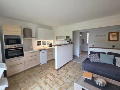 a kitchen and living room with a blue couch in it at Maison à Aix-en-Provence avec grand jardin in Aix-en-Provence