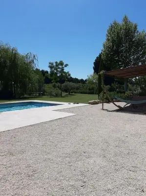 a swimming pool with a table and a bench next to it at Beau mas en campagne de l'Isle sur la Sorgue in LʼIsle-sur-la-Sorgue