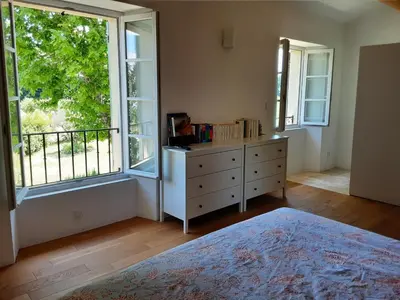 a bedroom with a dresser and a large window at Beau mas en campagne de l'Isle sur la Sorgue in LʼIsle-sur-la-Sorgue