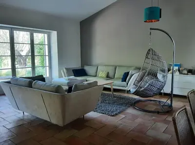 a living room with a couch and a hammock at Beau mas en campagne de l'Isle sur la Sorgue in LʼIsle-sur-la-Sorgue