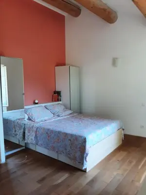 a bedroom with a bed and a refrigerator at Beau mas en campagne de l'Isle sur la Sorgue in LʼIsle-sur-la-Sorgue