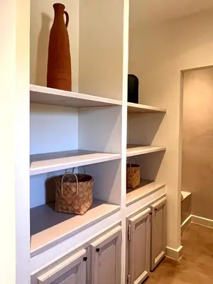 a closet with white shelves and vases on them at La Calade de Goult in Goult