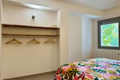 a bedroom with a bed and hangers on the wall at Comme Chez Mémé house with terrace in the center in Fontaine-de-Vaucluse
