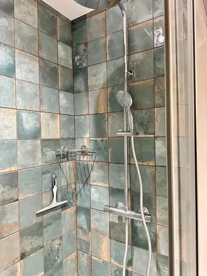a shower with a shower head in a bathroom at Comme Chez Mémé house with terrace in the center in Fontaine-de-Vaucluse