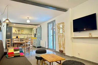 a living room with a couch and a table at Comme Chez Mémé house with terrace in the center in Fontaine-de-Vaucluse