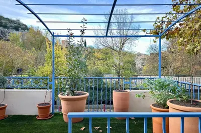 a dining room and living room with a table and chairs at Comme Chez Mémé house with terrace in the center in Fontaine-de-Vaucluse