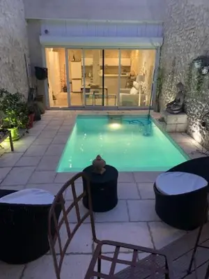 a swimming pool with two chairs and a table at Un havre de paix au coeur de la Provence in Châteaurenard